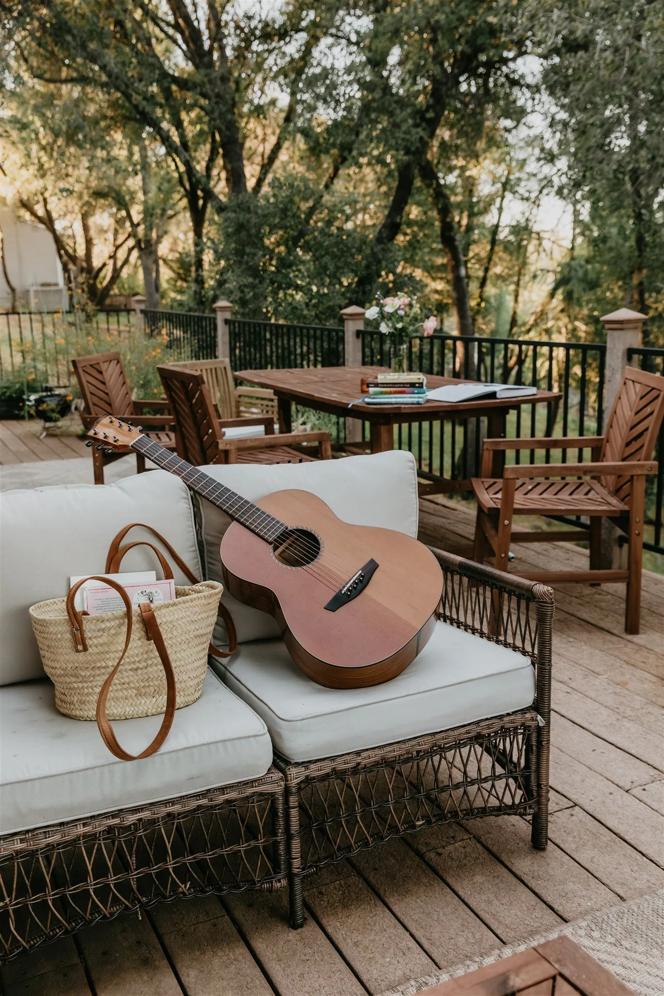 Peaceful outdoor therapy setting with guitar, books, flowers, and a woven bag