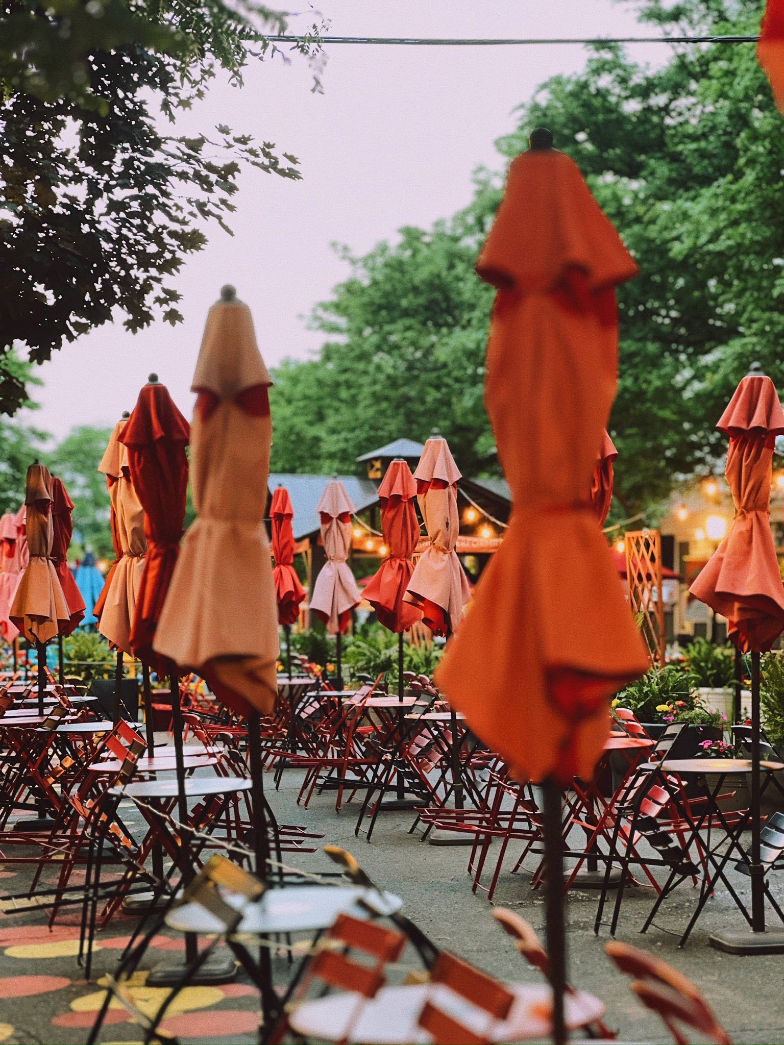 Summer on Strong at Strong Avenue in Northampton - outdoor dining tables with the red umbrellas down and tied neatly in the evening