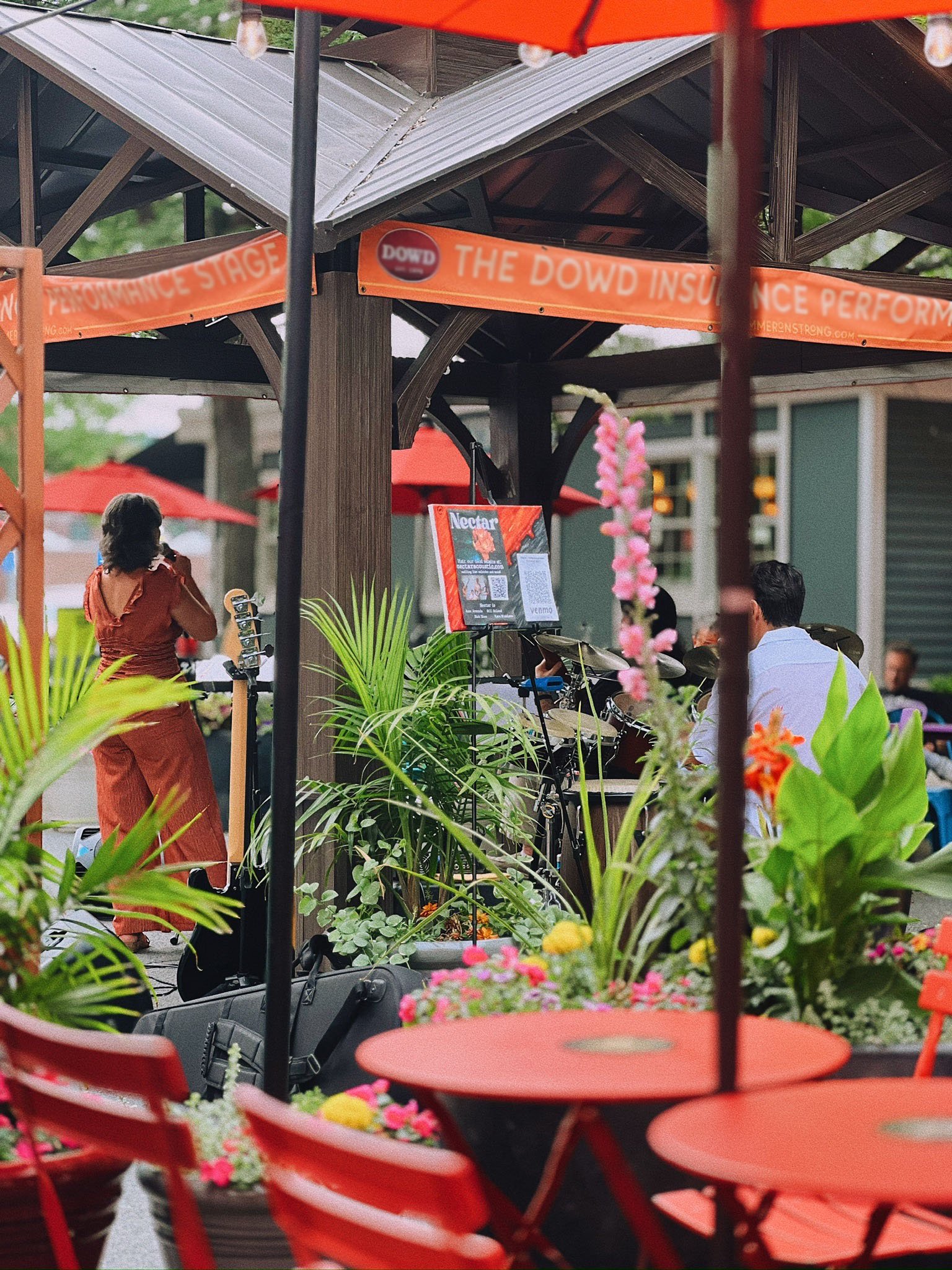 Summer on Strong at Strong Avenue in Northampton - outdoor dining tables with colorful plants and a view of the music pavilion