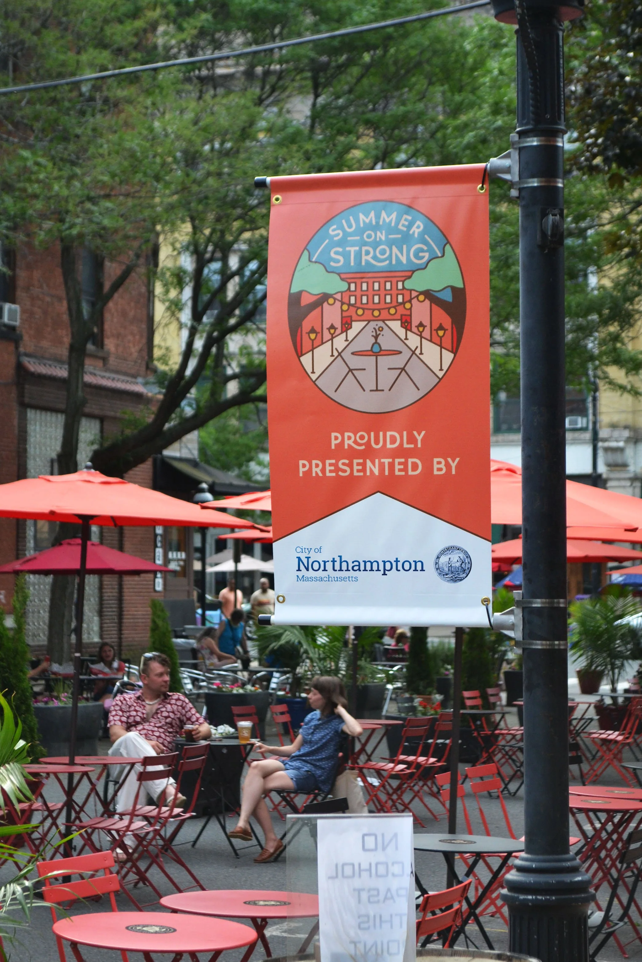 Summer on Strong at Strong Avenue in Northampton - outdoor dining with the City of Northampton sponsorship banner in the foreground