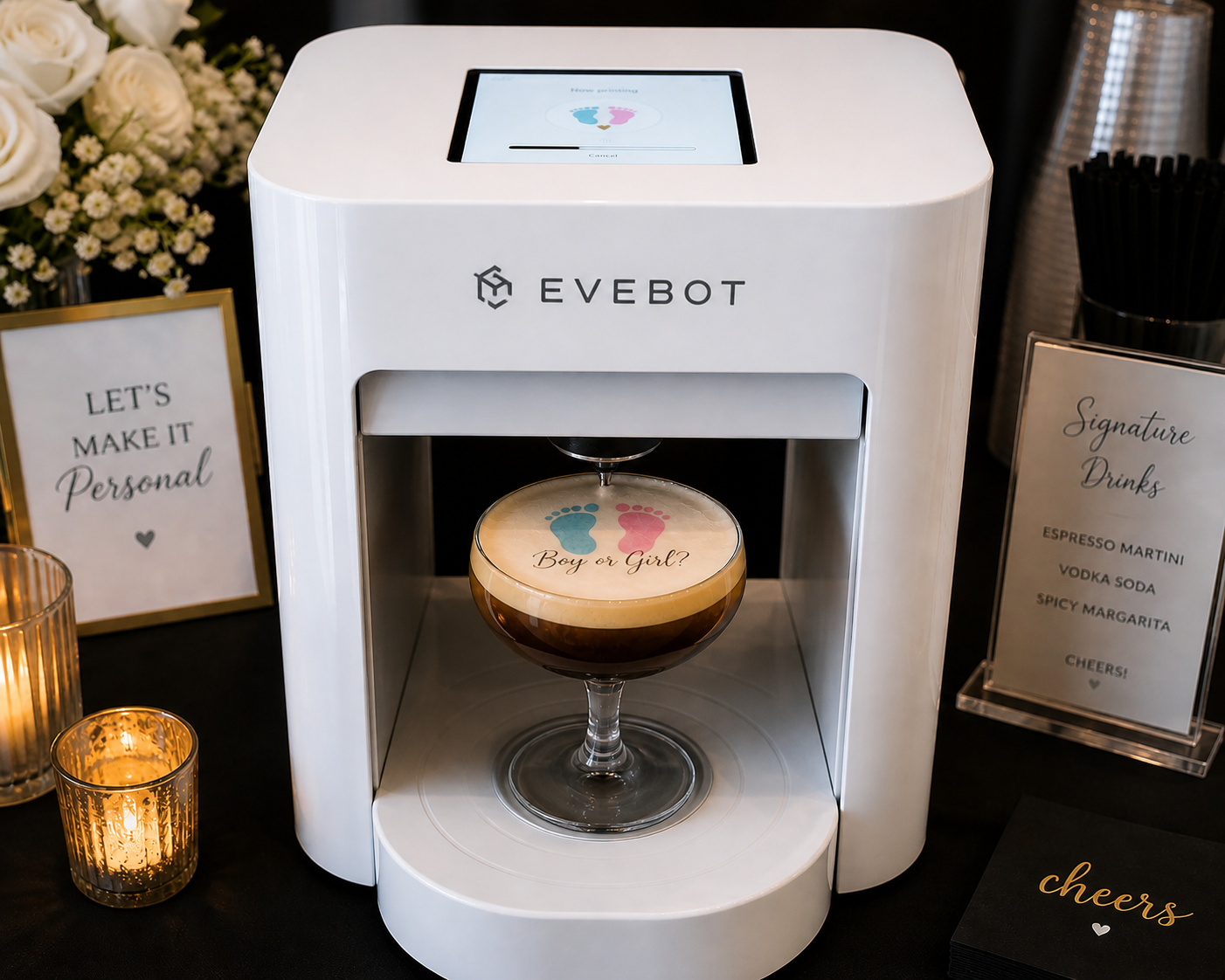 A coffee machine with a sign asking if it's a boy or girl, with a cappuccino inside. The cappuccino has a foam top with blue and pink footprints and the words 'Boy or Girl?' on it.