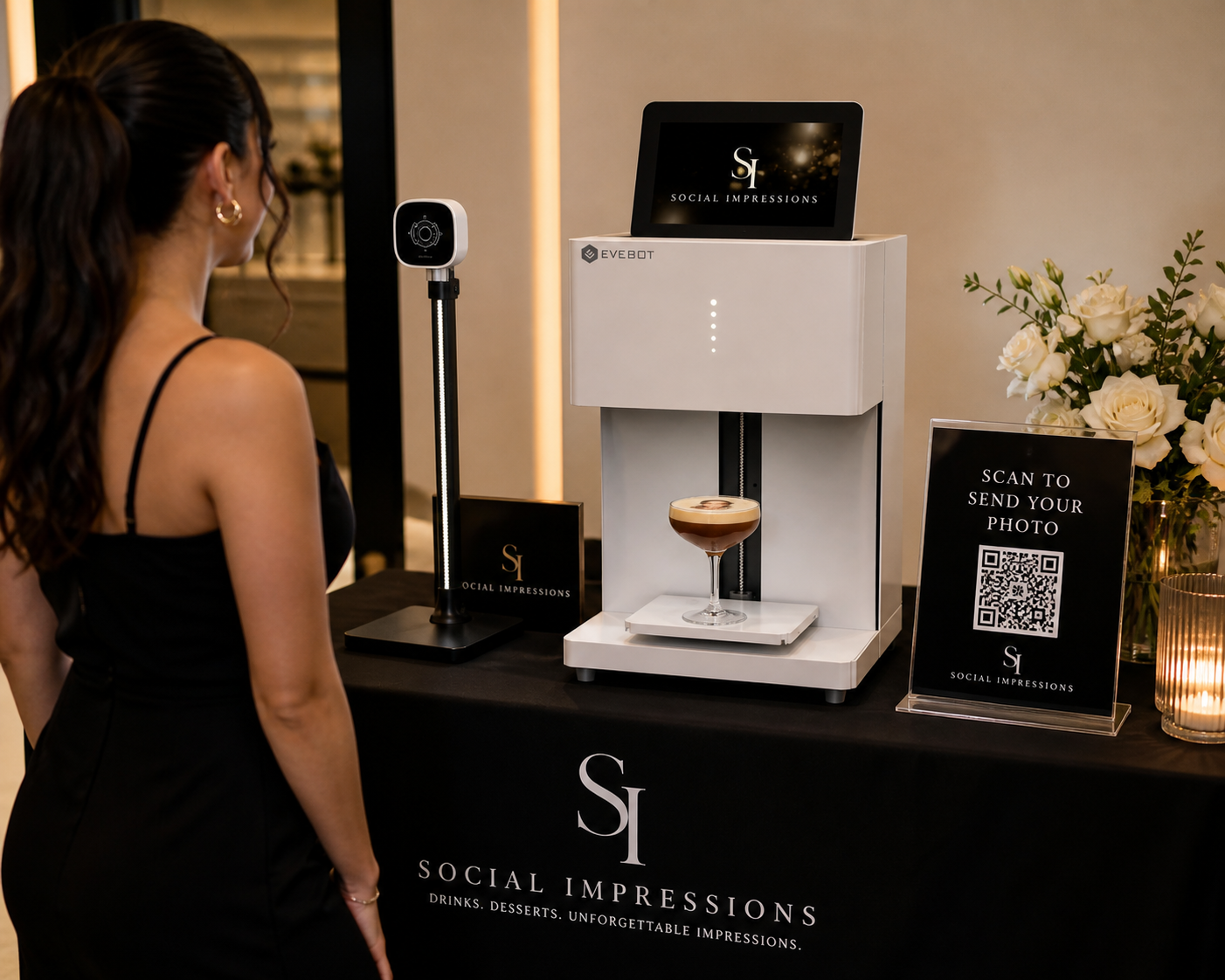 A woman in a black dress looking at a coffee machine that is taking a photo of her to create a social media impression. The setup includes a digital scale, a QR code sign for sending photos, and a display screen with the 'Social Impressions' logo.