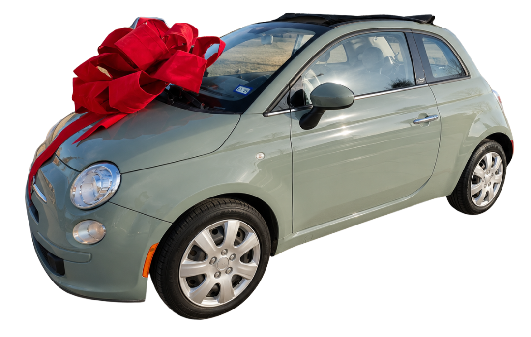 A light green Fiat 500 car with a large red bow on the hood, indicating it is a gift.
