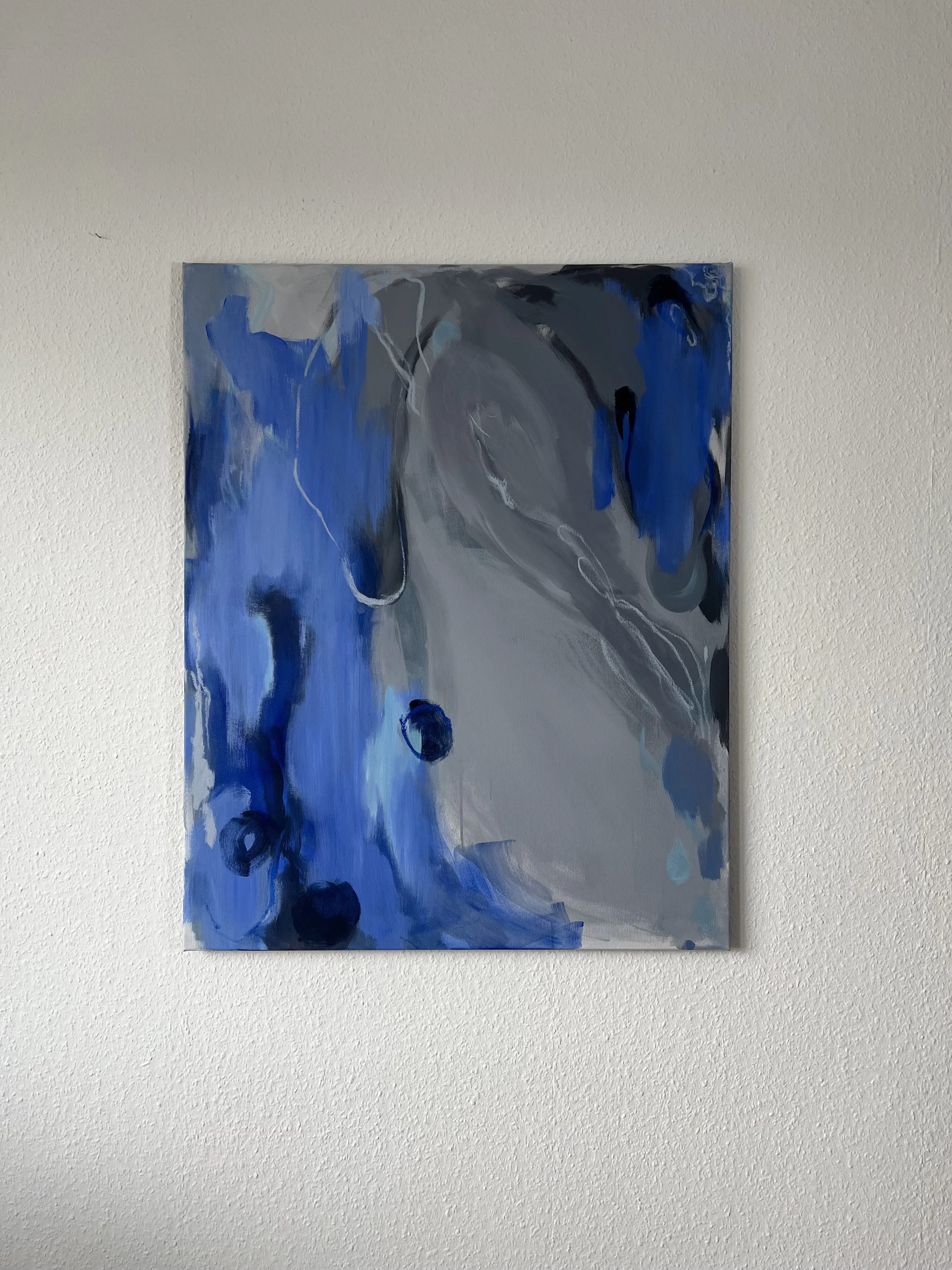 Abstract painting with blue, black, gray, and white brushstrokes on a canvas.