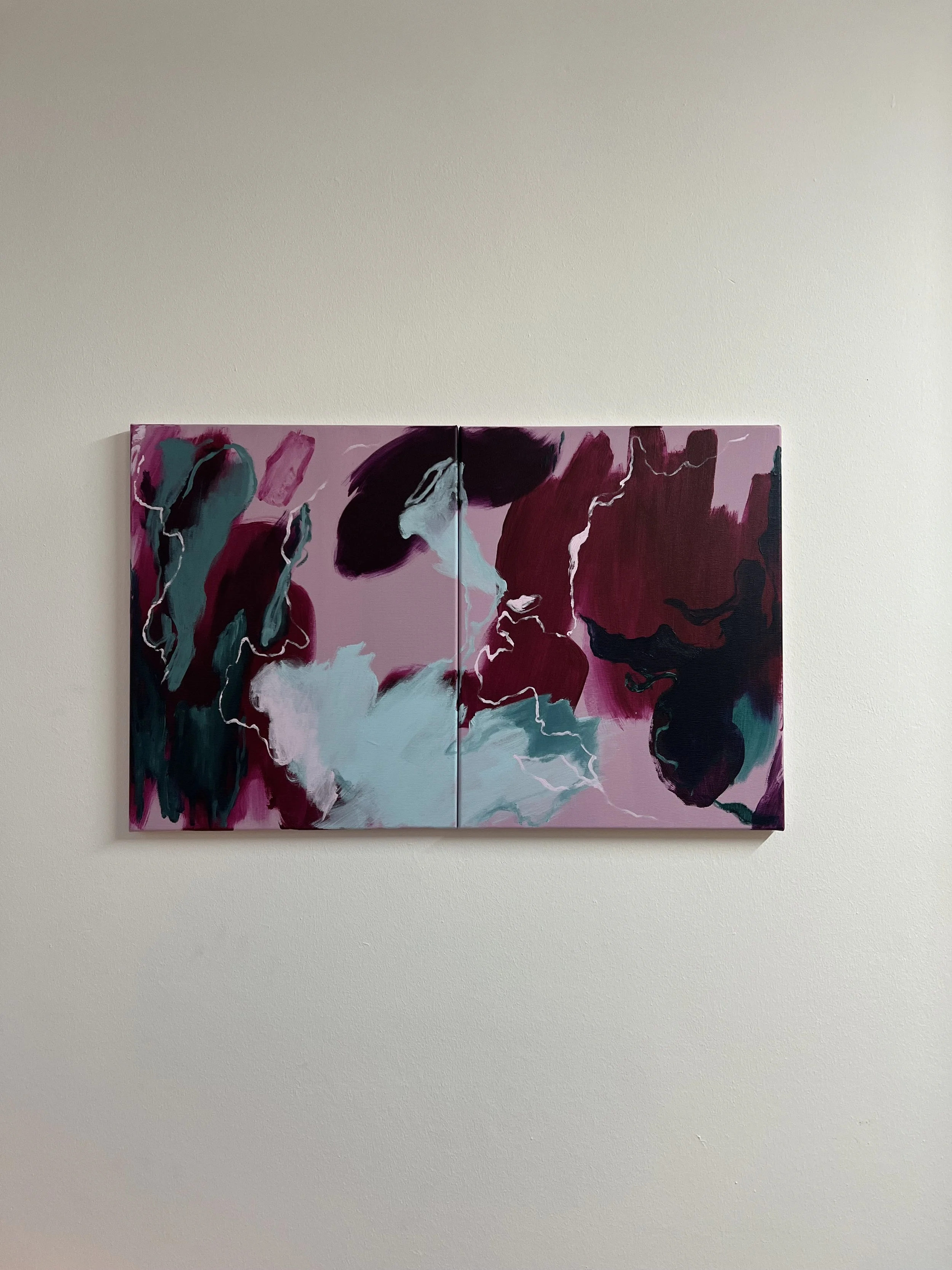 Abstract painting with pink, dark red, black, teal, light blue, and white colors on a beige wall.