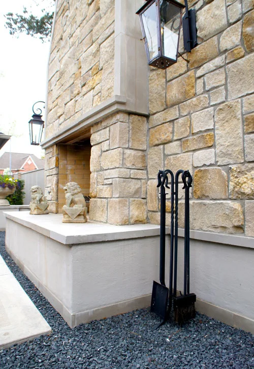 Left: Side view of outdoor fireplace. Lion statuary and lanterns add to the symmetrical impact of this french-inspired courtyard.