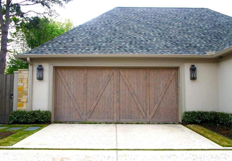 View of garage door. Stone stepping pads lead to gate and driveway was completed with a rock salt finish to add visual interest.