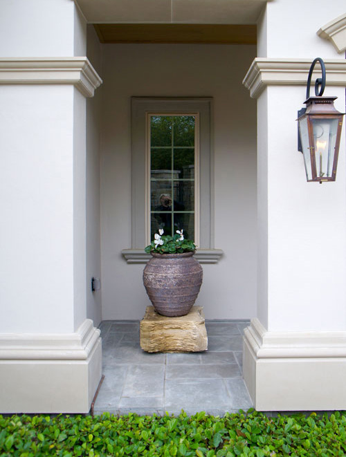Right: Cyclamen in a centered planter atop a stone pedestal. Sandy Leaf Fig Ivy line the stone patio.