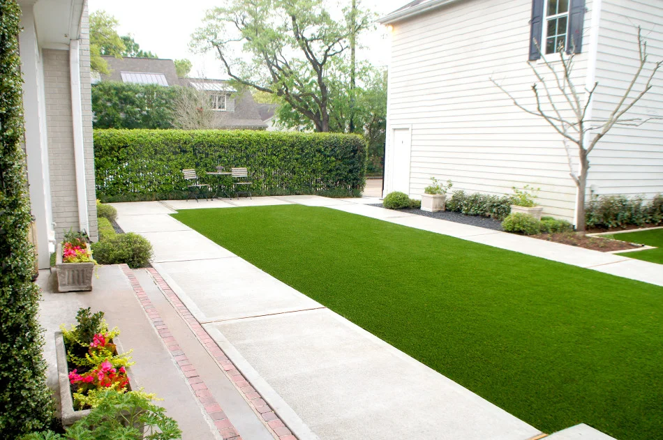 Contemporary landscape design offers a grand simplicity to this English traditional cottage in West University, Houston.