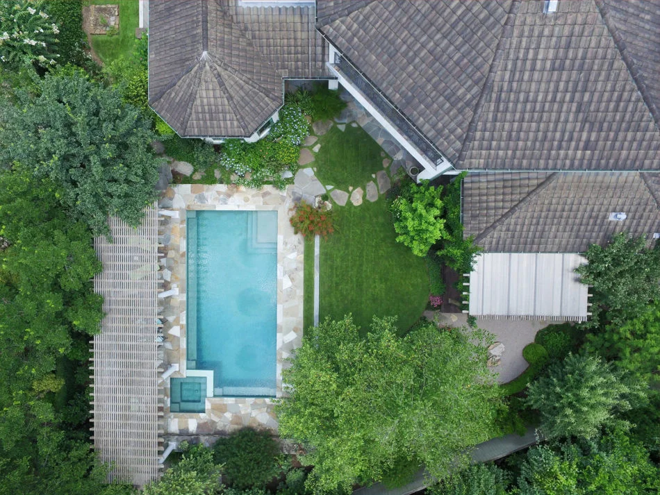 Flagstone was used to deconstruct the sharp edge of the pool which now leads to a circular stone path acting as a fulcrum for the veranda.