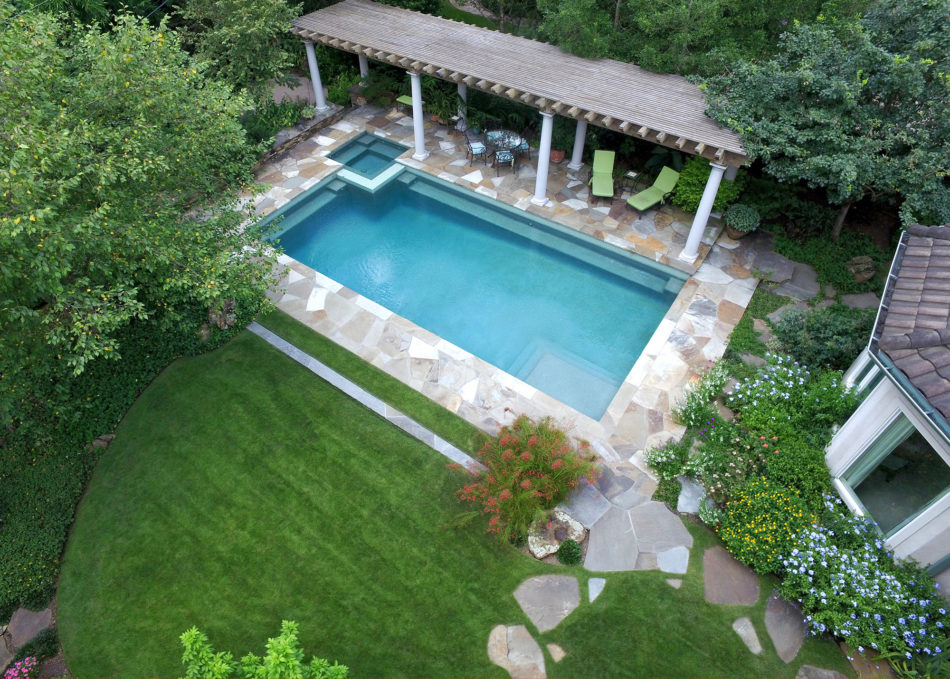 The use of circles and ellipses in this space give a bold, expressive sense of unity that cohesively connects the pool, house, and raised deck, creating a sense of oneness throughout. Flagstone was used to deconstruct the sharp edge of the pool whic…