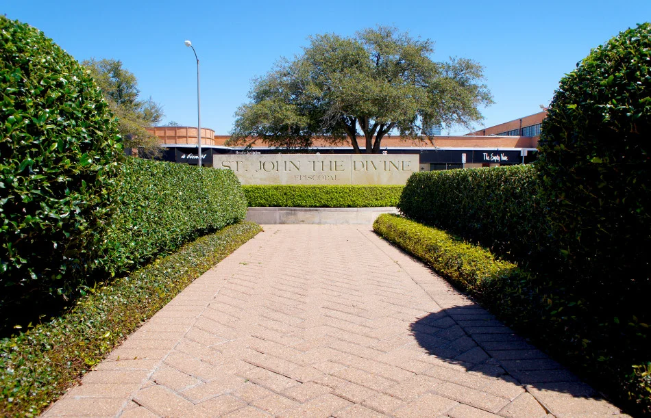 Red brick path leading to sign and lined with pruned boxwood hedges and asian jasmine.