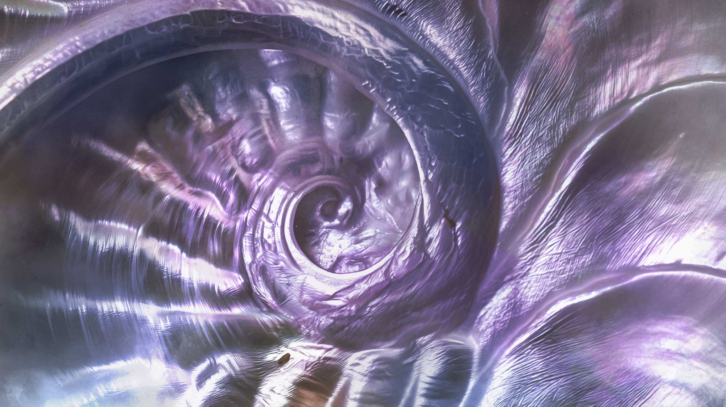 Nahaufnahme einer spiralförmigen metallischen Oberfläche mit reflektierenden, lilafarbenen Tönen.