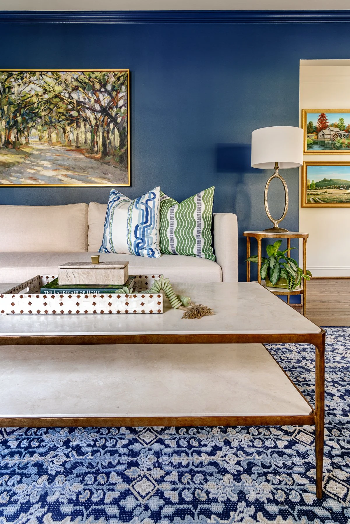 Living room with blue accent wall and gallery-style art display, Winston-Salem interior design