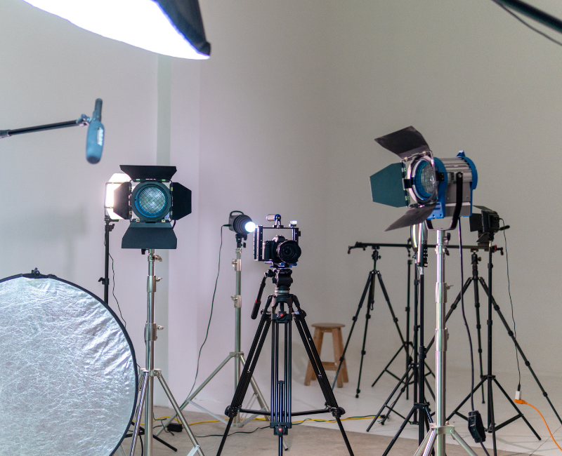 Photography studio with professional lighting, cameras, and equipment setup for video or photo shoot.