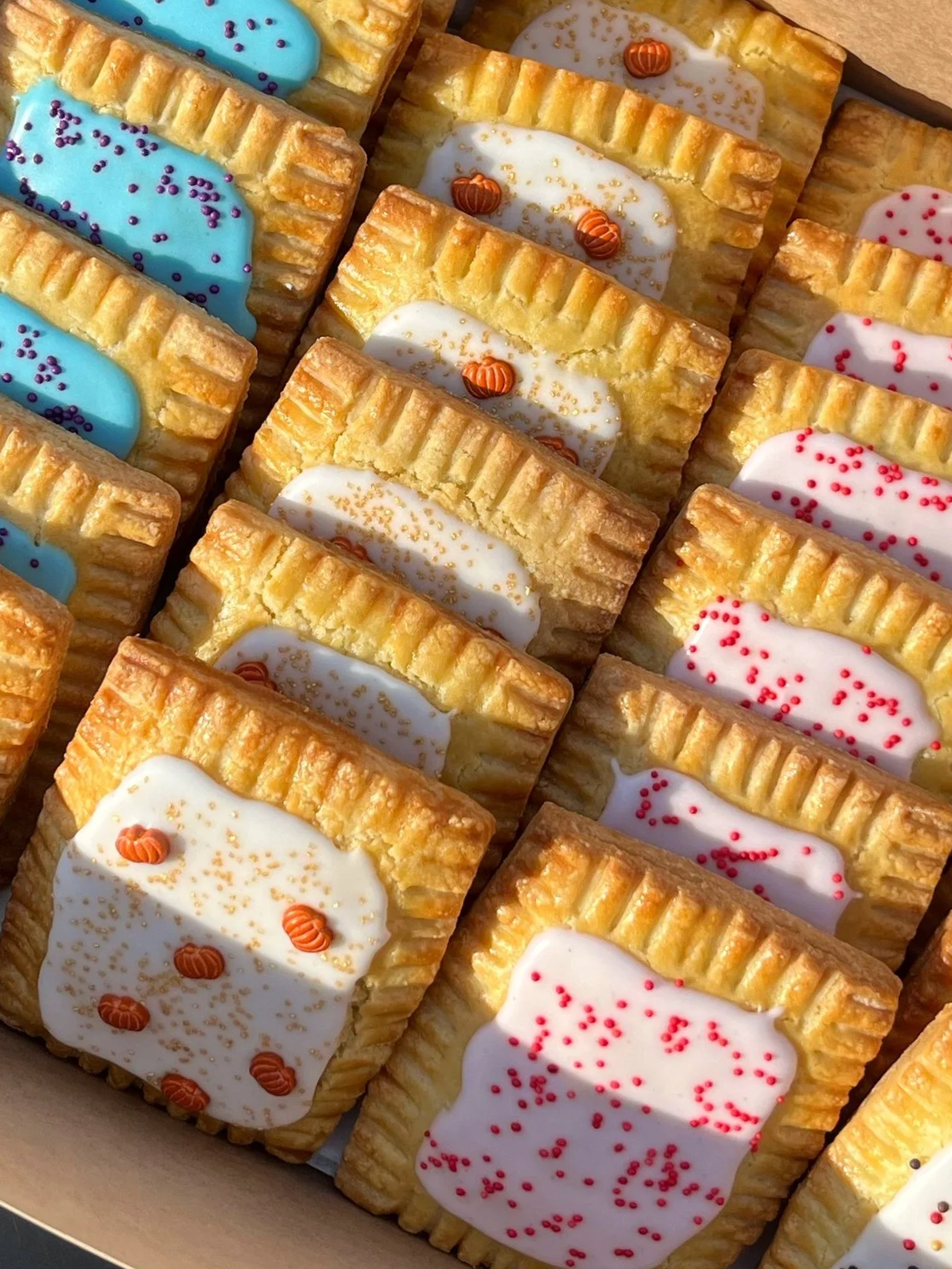 Close-up of assorted rectangular frosted cookies with colorful icing and sprinkles.