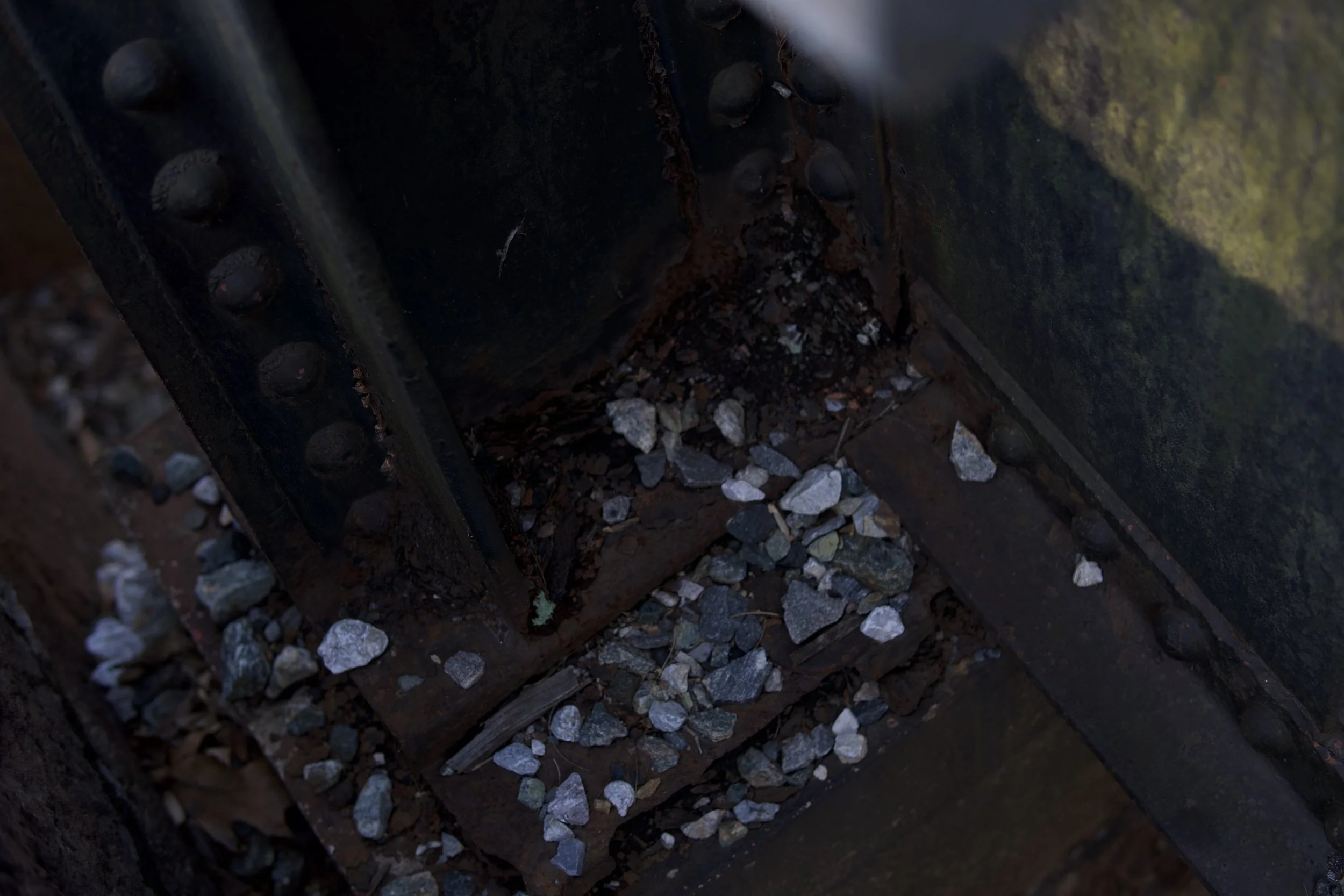 Close-up of a section of a railway track with rusted metal and scattered rocks underneath.