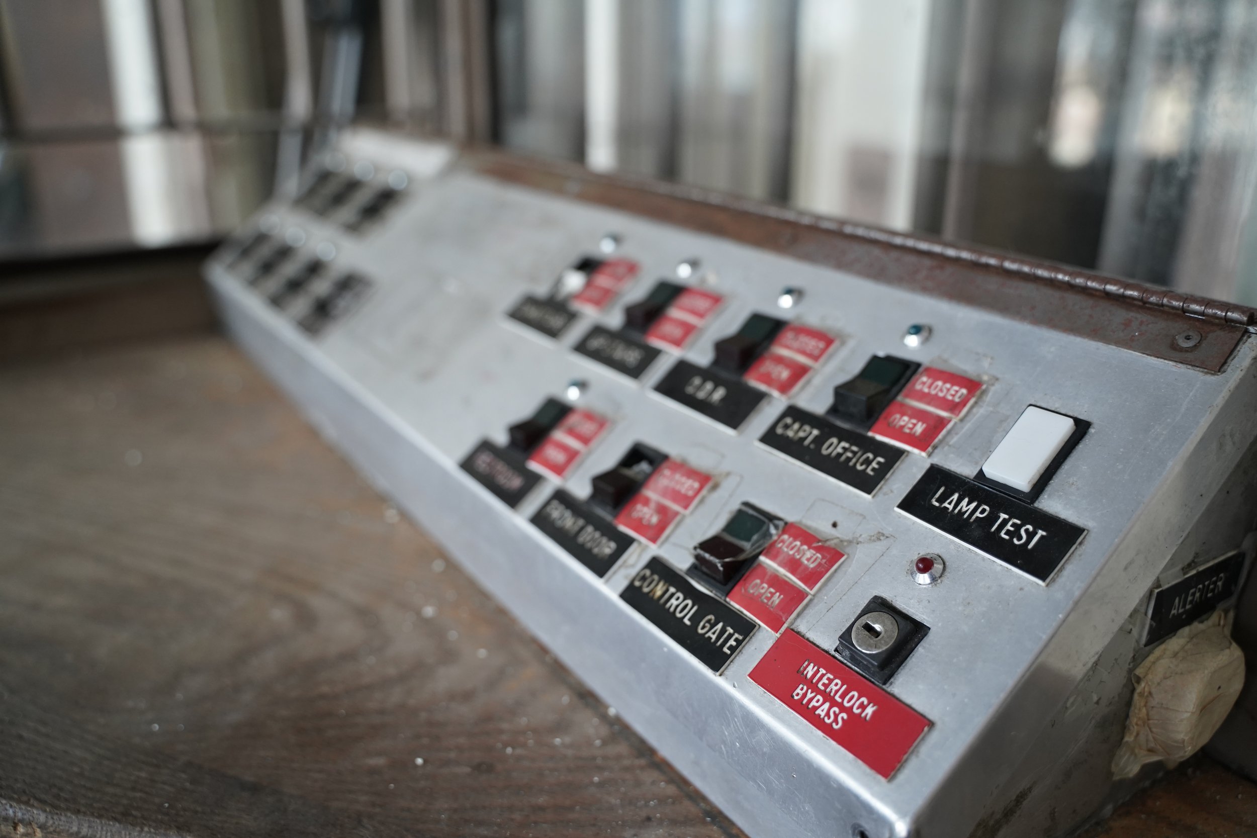 Close-up of an old industrial control panel with multiple switches and labels, some labeled 'CLOSED,' 'OPEN,' and 'CONTROL GATE.'