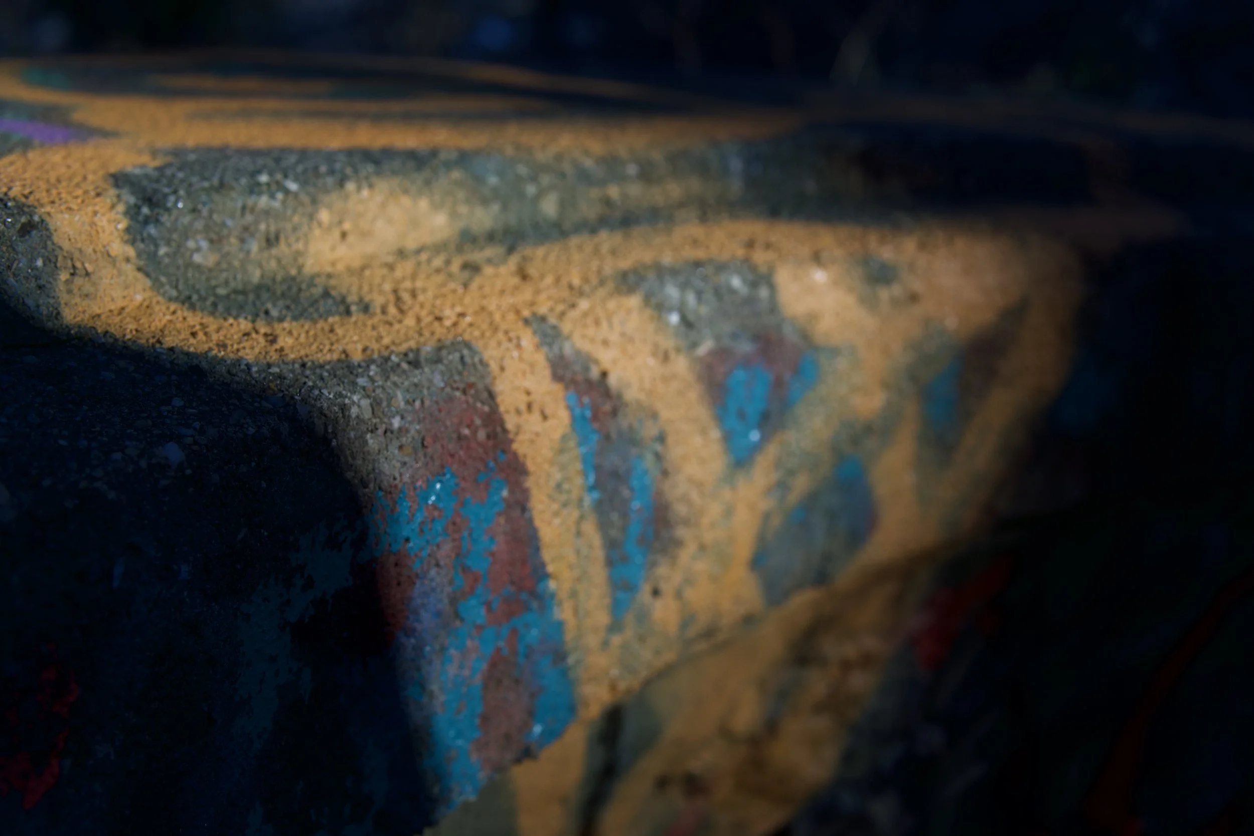 Close-up of colorful, textured graffiti on a brick wall.