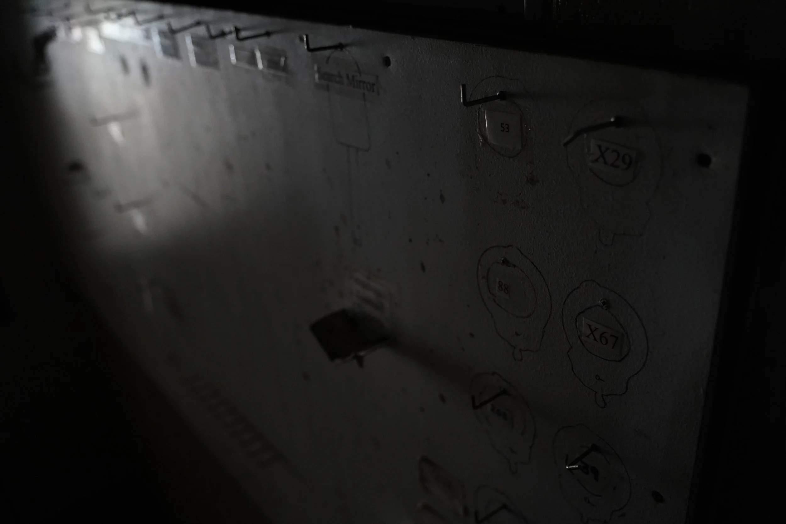 Close-up of a section of an electrical or electronic device panel with various circular and rectangular indicators and labels, some showing numbers like 53 and 29, amidst a dark background
