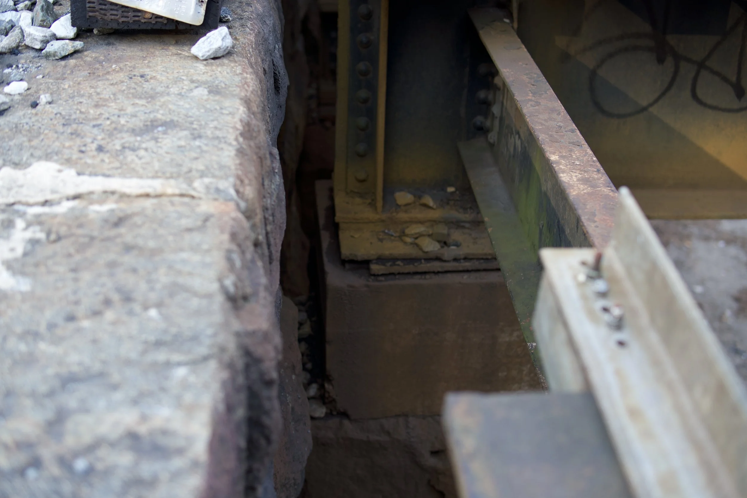 Close-up view of a railway track with stone ballast and a rail fastener securing the rail to the ties.