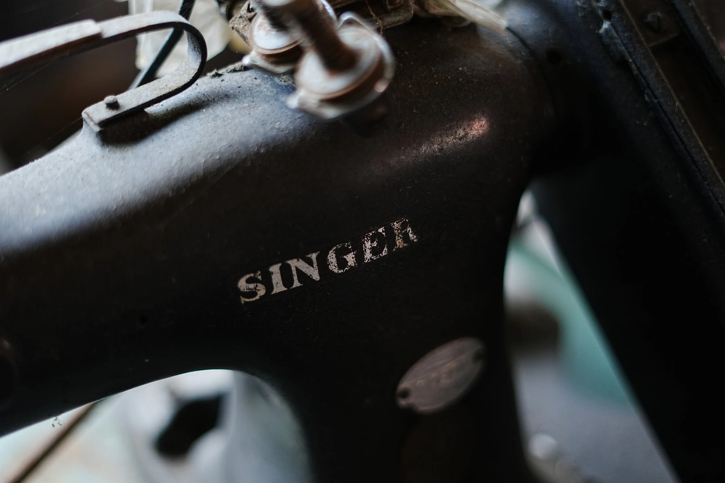 Close-up of a vintage Singa brand electric motor with rusted metal parts and a worn label, showing signs of age and use.