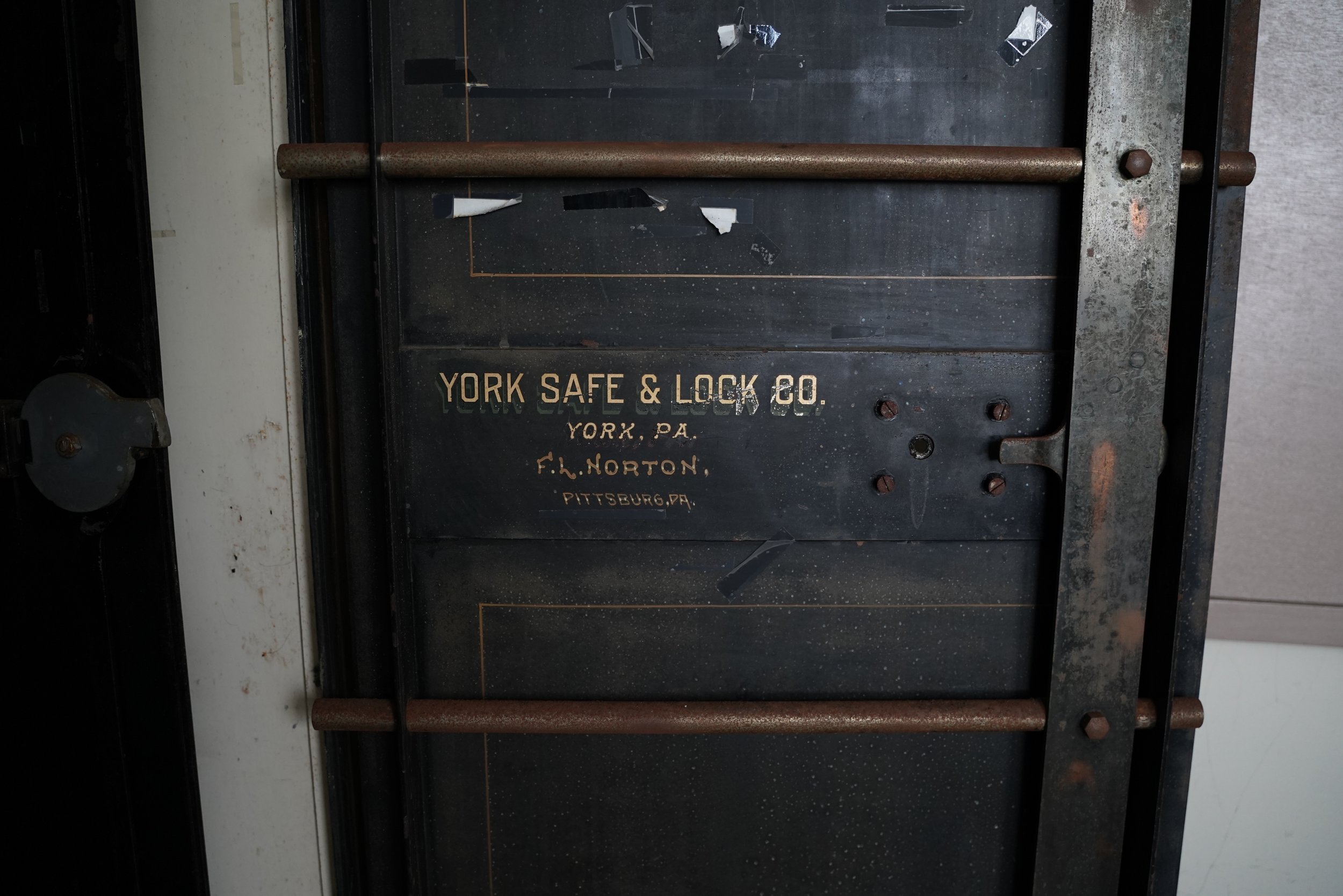 An old metal safe lock with the words 'YORK SAFE & LOCK CO. YORK, PA. F. L. NORTON, PITTSBURG, PA' written on it.