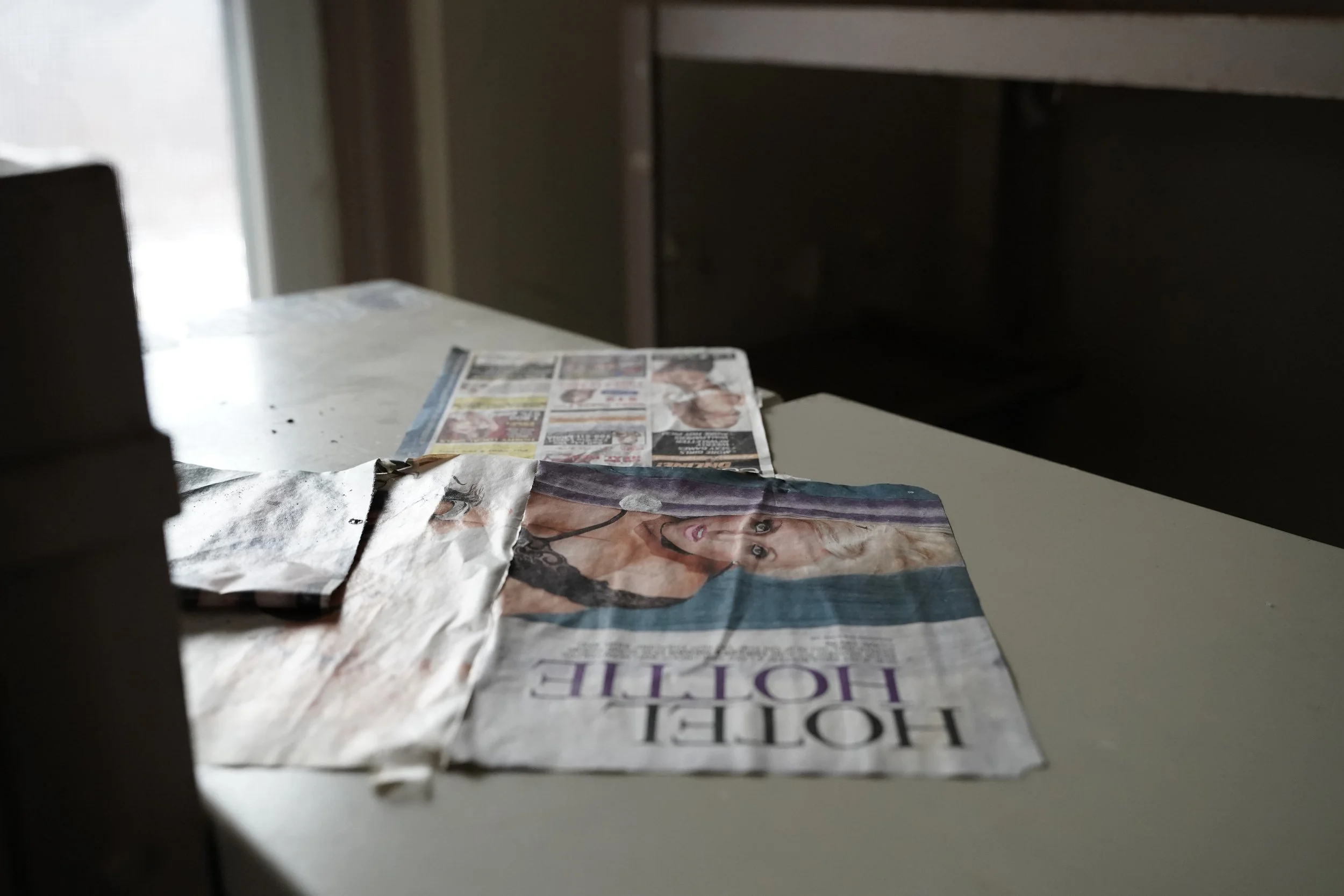 A crumpled newspaper on a table with a headline about Hollywood and a photo of a woman.
