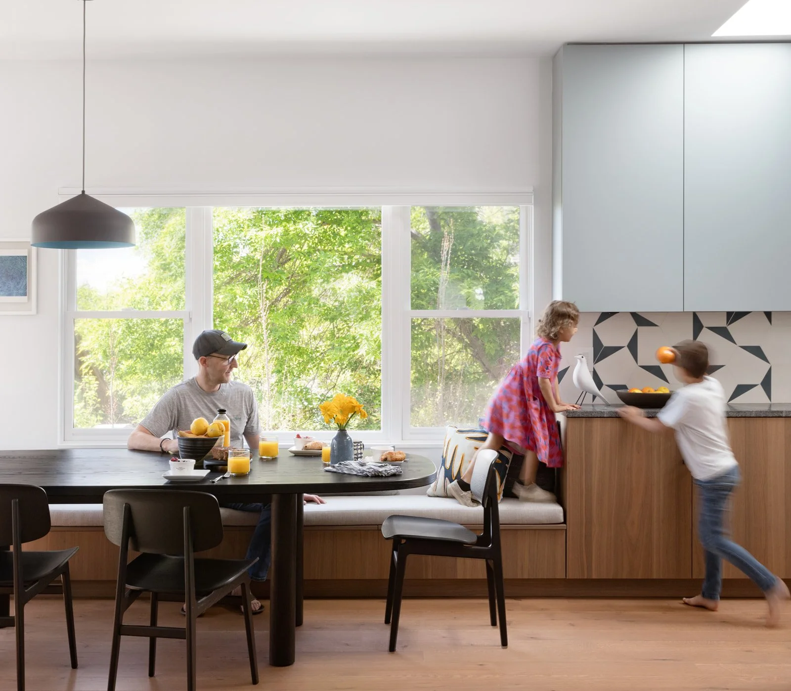 A family sits in their eat-in kitchen nook in their newly remodeled Boulder, CO home.