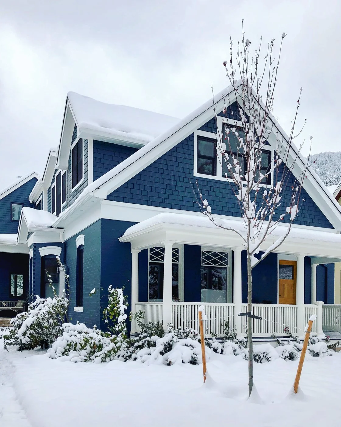 Exterior of deep blue remodeled brick home with white trim in snow.jpg