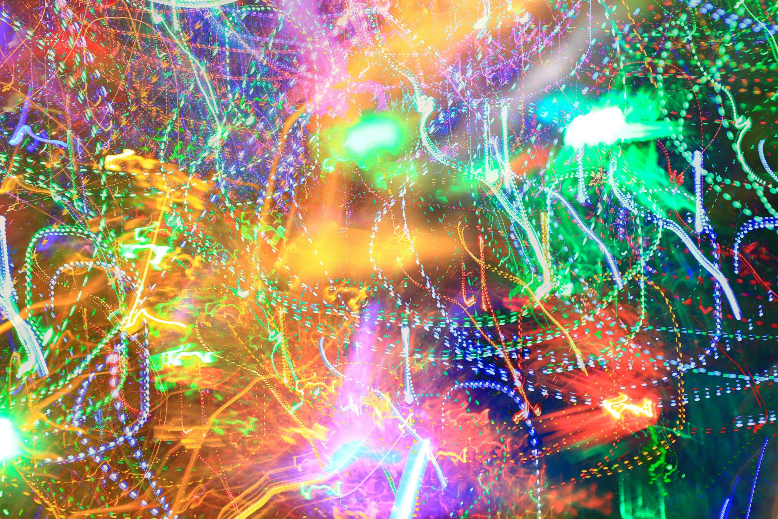 A colorful abstract display of neon lights and trails creating a vibrant, chaotic pattern.