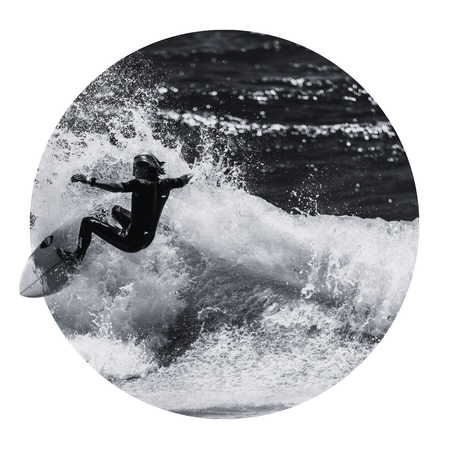 A person surfing on a wave in the ocean, captured in black and white.