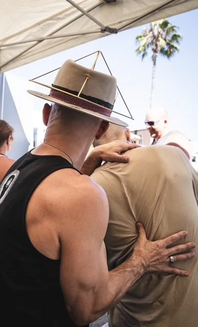 Chiropractor, Dr. Jeremy Brooks, performing a chiropractic adjustment on a man's spine in an outdoor setting