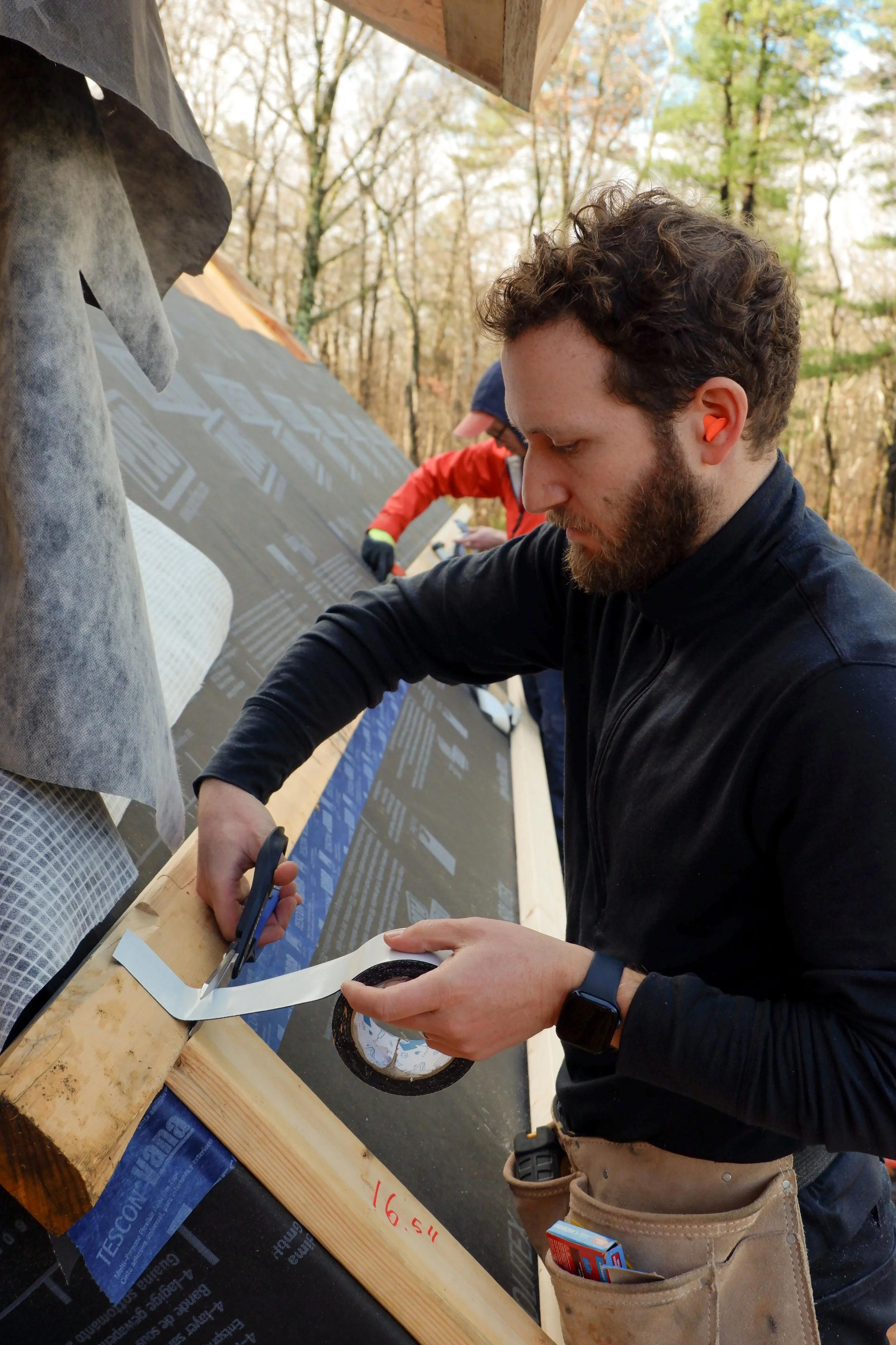 Two men working on the air sealing for a passive home.