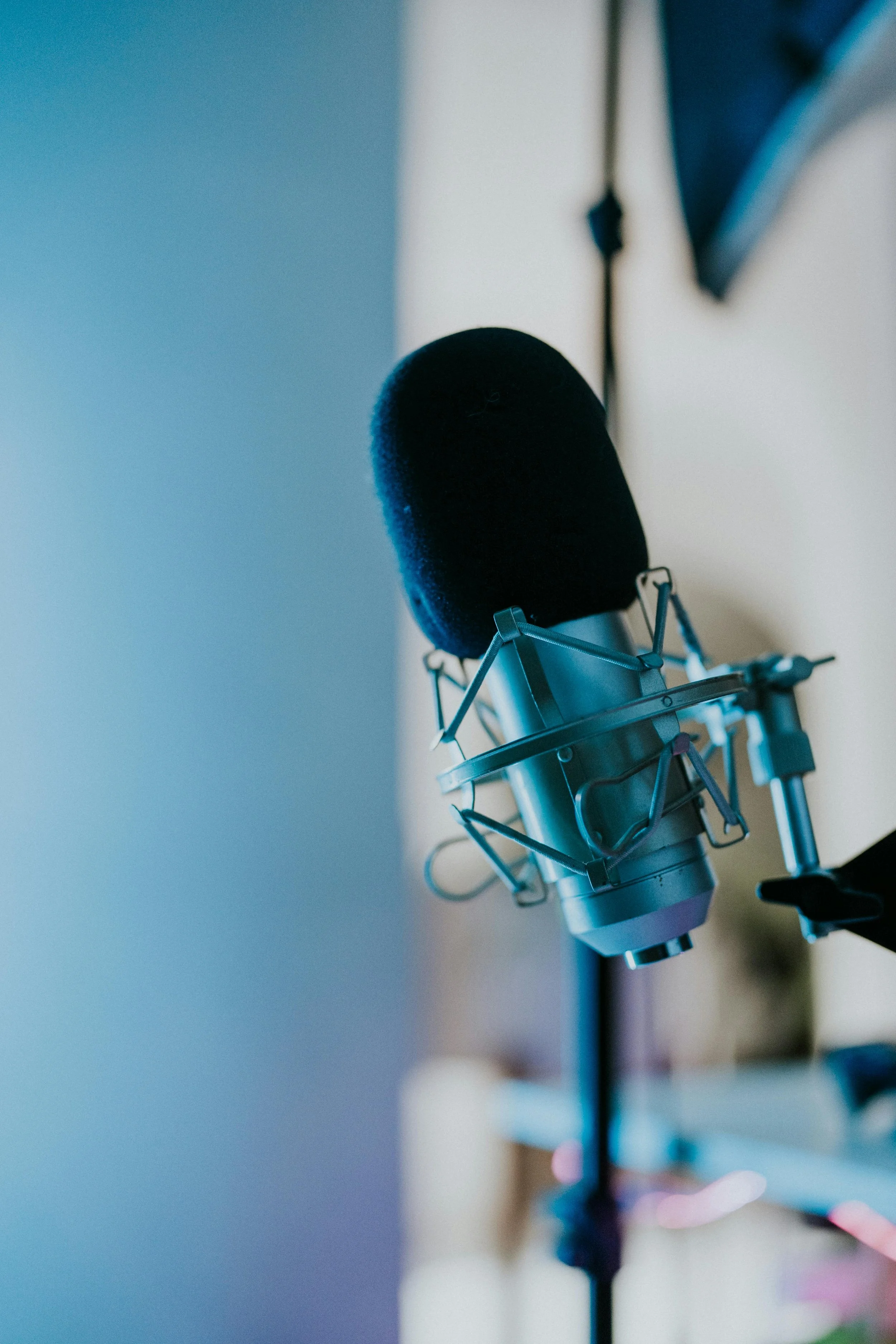 A microphone stands waiting in a blue and white room.