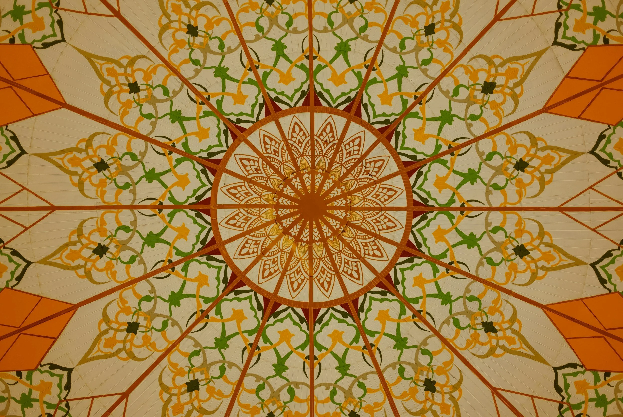 mandala with yellow, green, black, and red colors, in circles, gradually getting larger as it moves from center