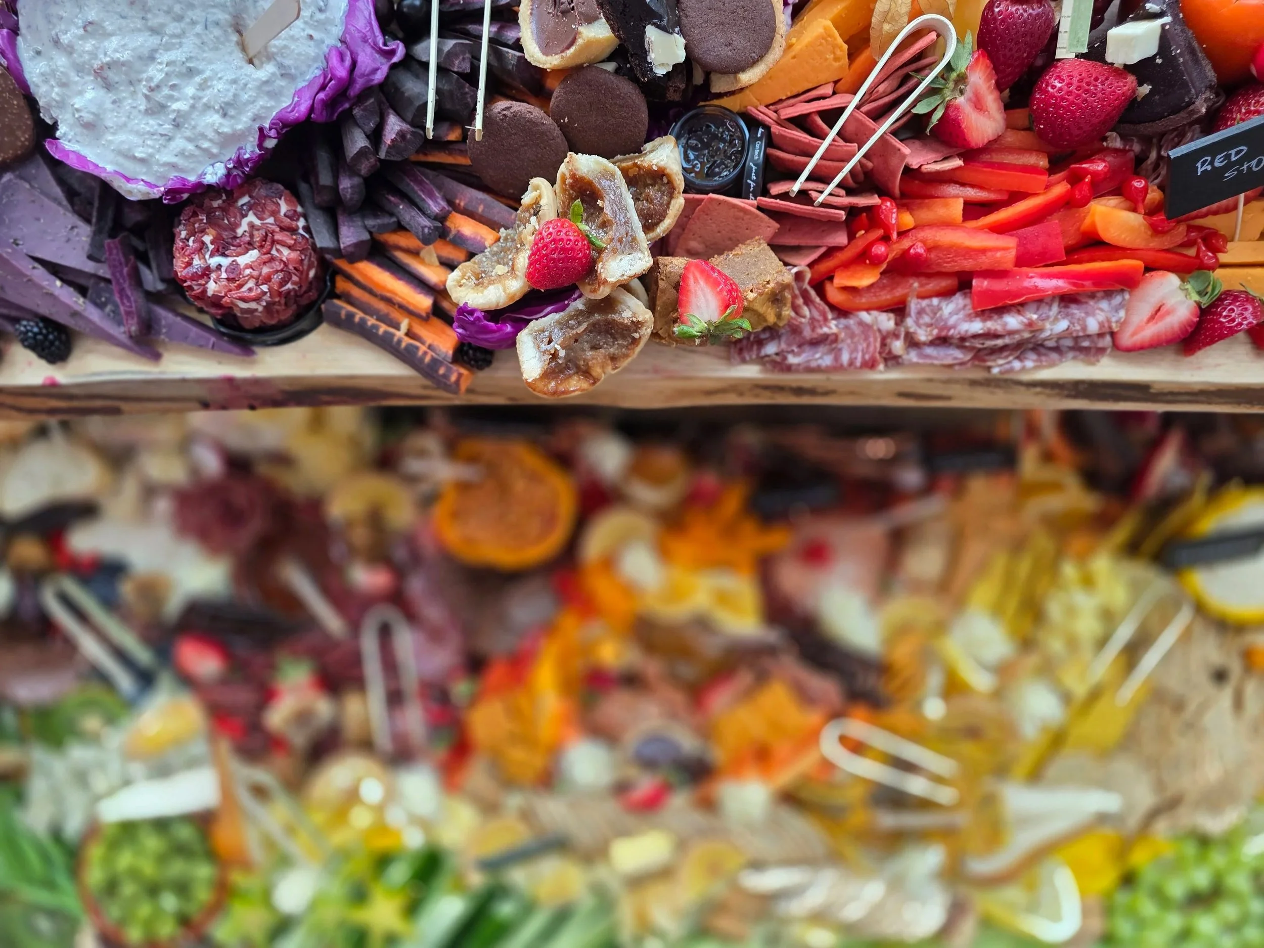 A generous grazing table full of cheese, charcuterie, treats, veggies and dips along with bread and crackers. Group catering, impressive table-scapes. Fresh produce, cooking with colour, event upgrapes