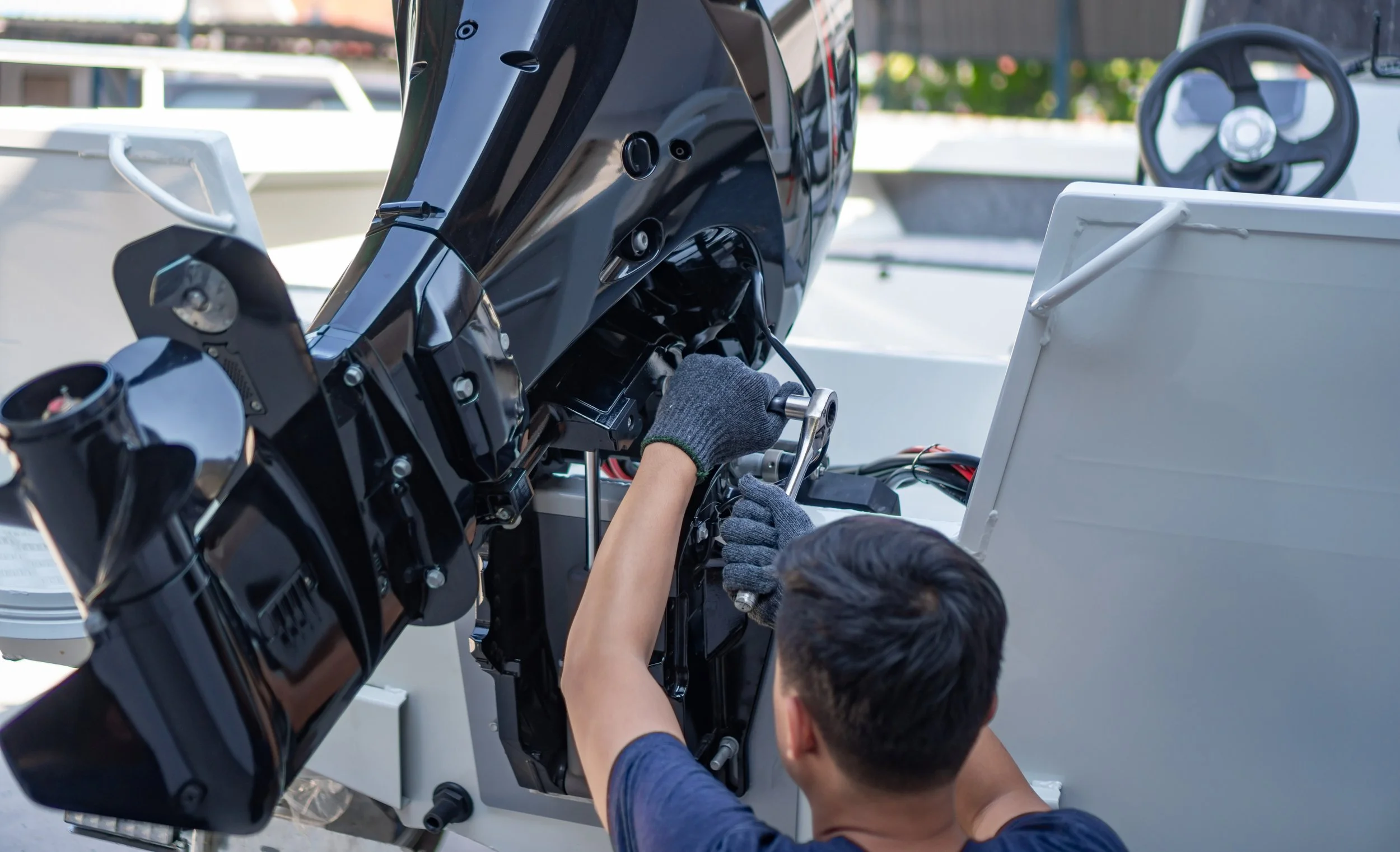 Two people working on the wiring of a boat engine.