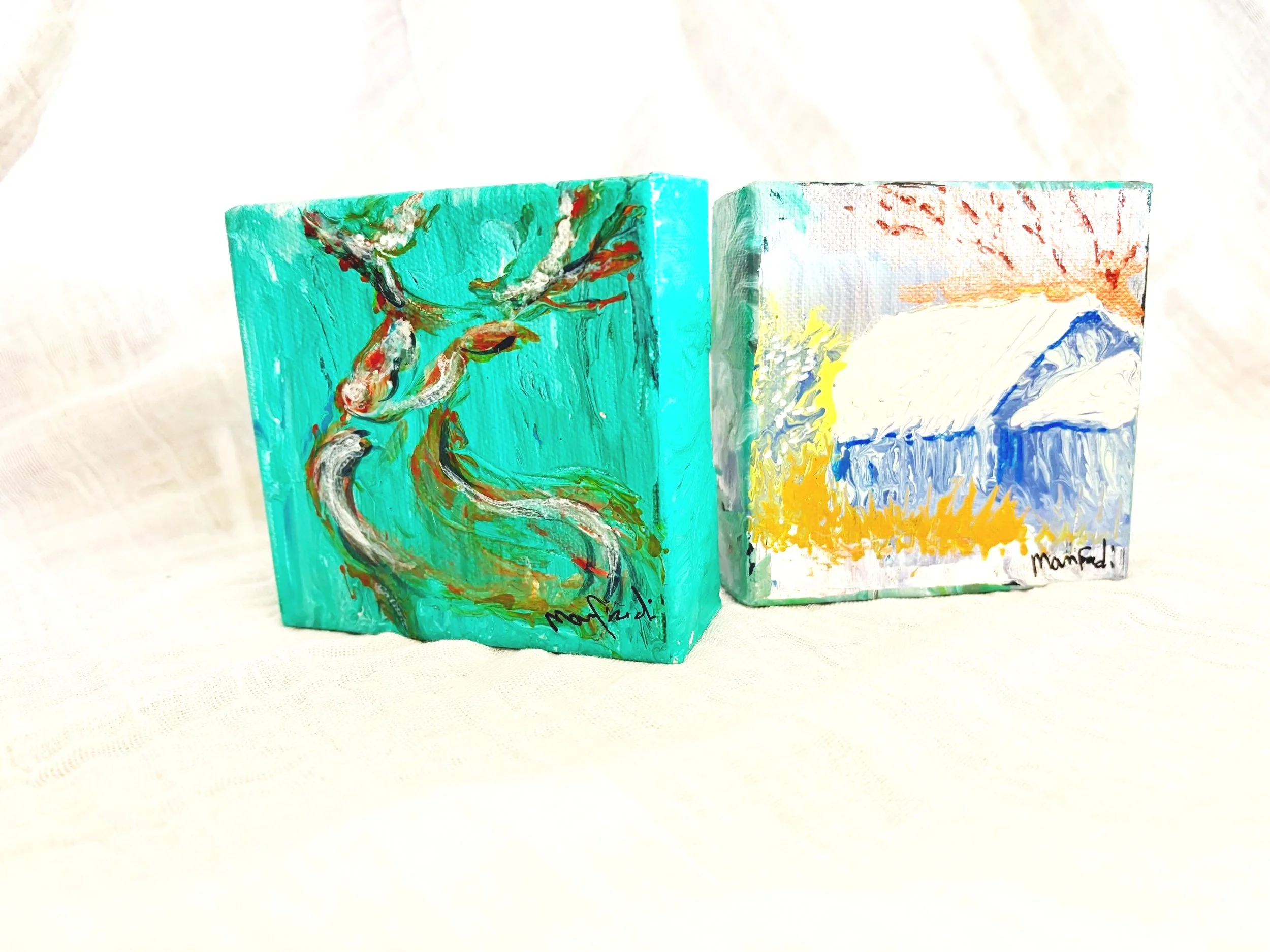 Two small, brightly colored, abstract paintings with various brushstrokes and textures, signed at the bottom.