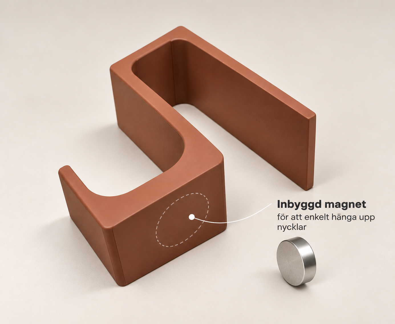 En U-formad bronsfärgad magnet och en liten rund metallmagnet. Texten beskriver att den inbyggda magneten är enkel att använda för att hänga upp nycklar.