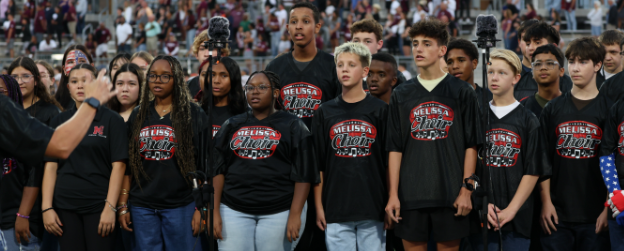 Students singing the National Anthem at a football game