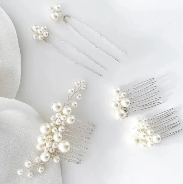 Collection of pearl-embellished hairpins and hair accessories on a white surface.