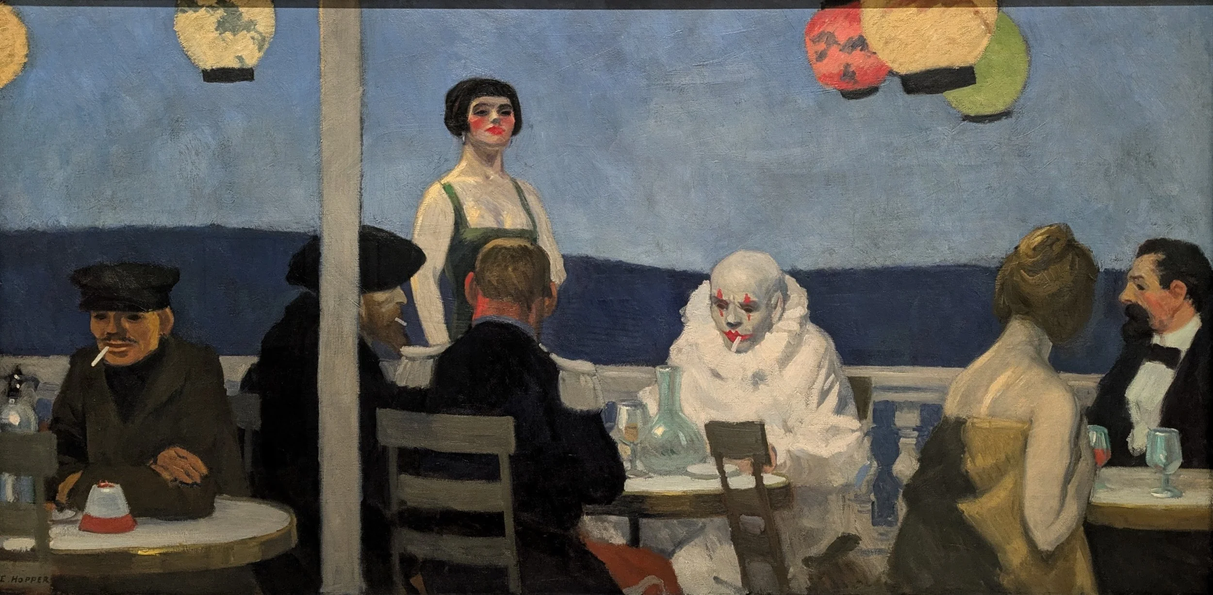 A painting of a dinner scene with several people, including a woman with clown makeup, a woman with her back to the viewer, and others sitting at tables, under hanging lanterns.