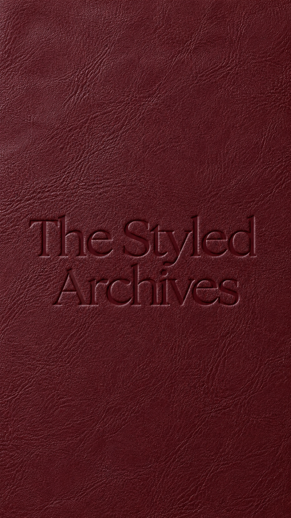 Close-up of a maroon textured leather cover with embossed text reading 'The Styled Archives'.