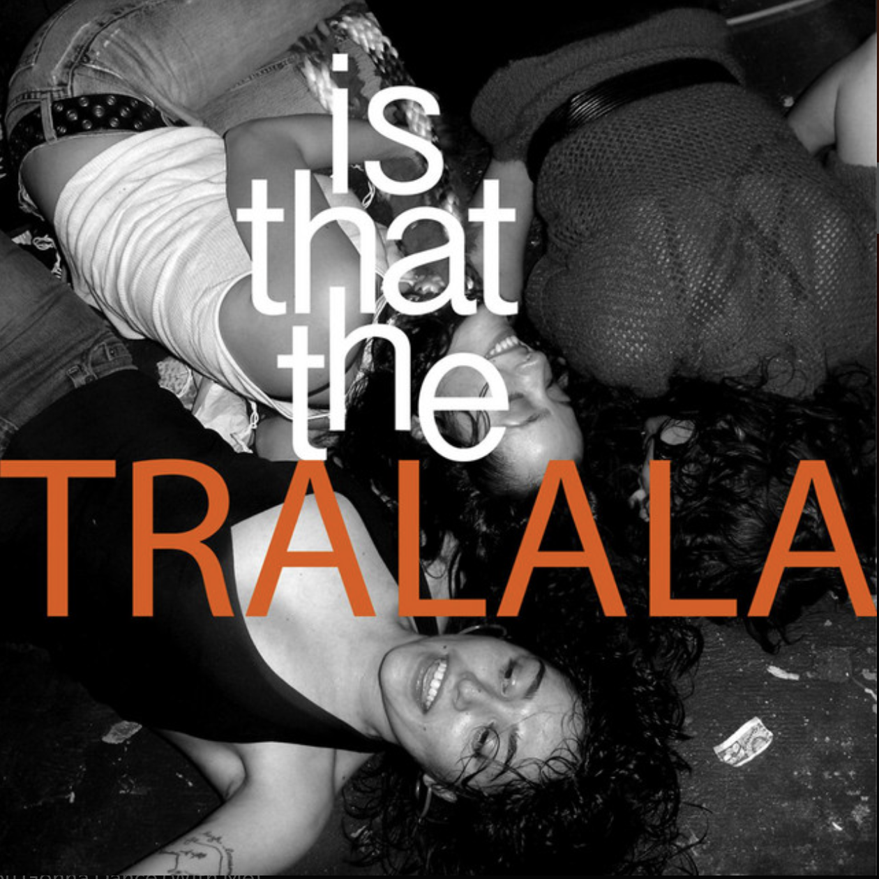 Three women lying on a dark floor, smiling and laughing, with overlay text reading 'Is that the TRALALA' in orange and white letters.