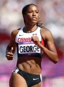 A female athlete running in a track and field event at the London 2012 Olympics, wearing a white and black sports uniform with her name George on the bib.