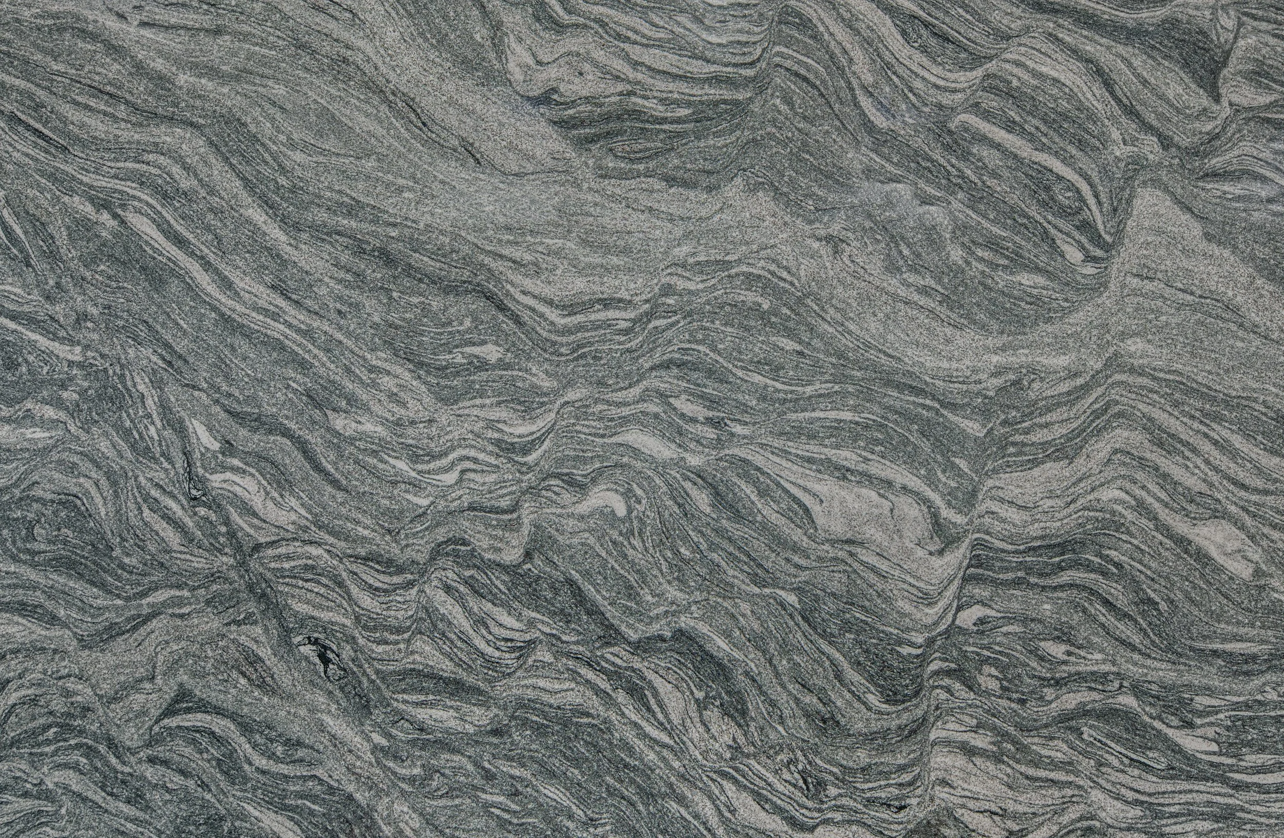 Close-up of a gray and black marbled stone surface with intricate swirling patterns.