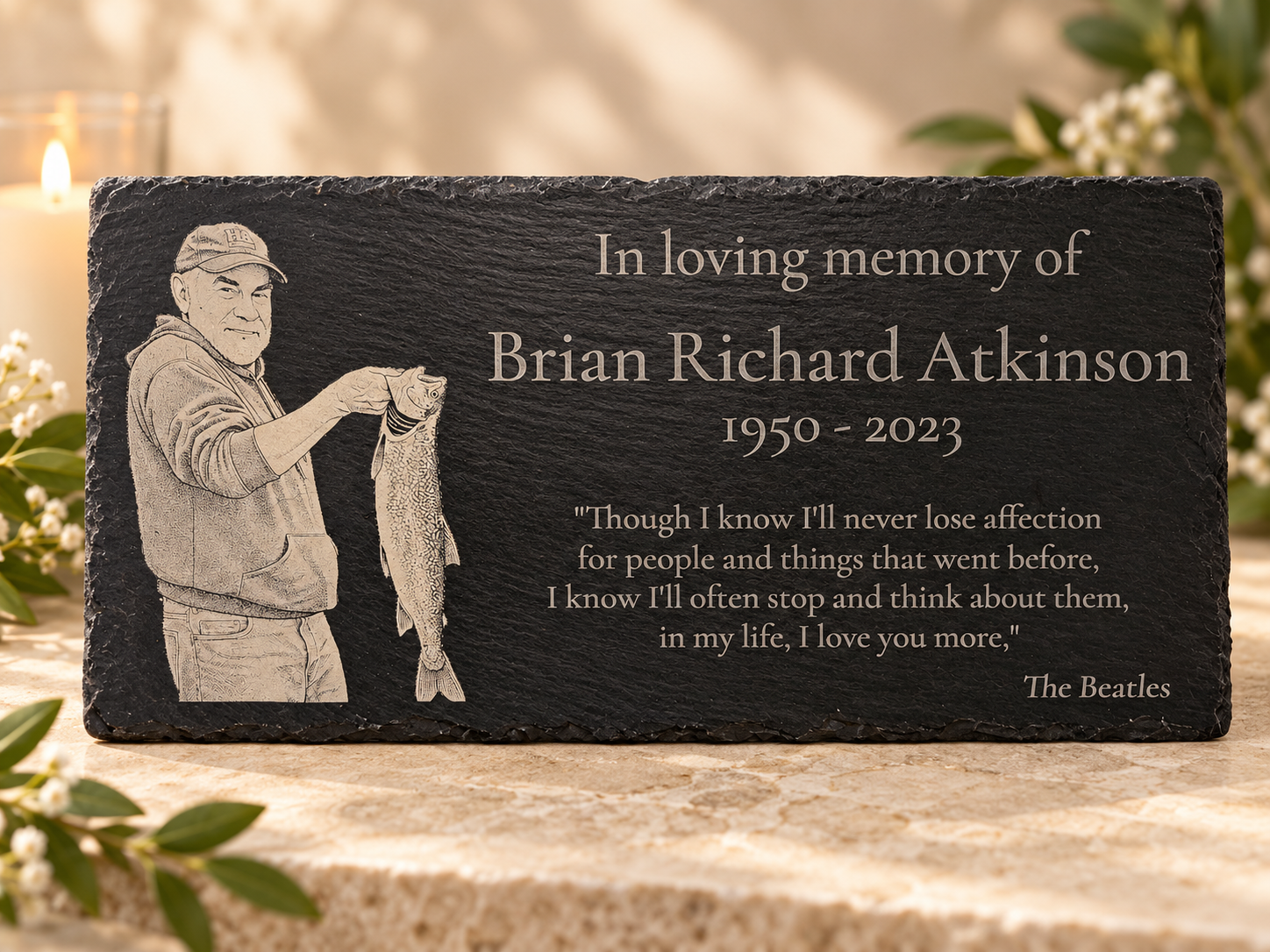 Memorial plaque featuring an engraved illustration of a man holding a fish, with flowers and a candle in the background, dedicated to Brian Richard.