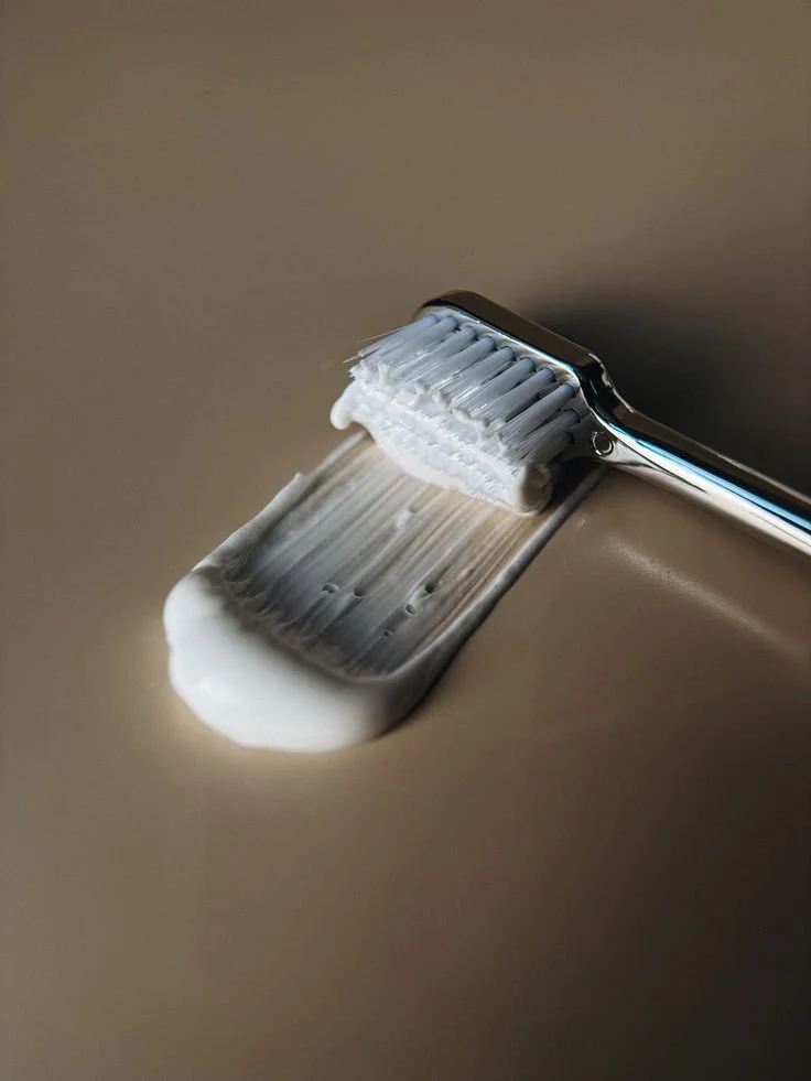 A toothbrush with foam on its blades, resting on a flat surface.