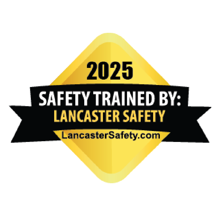 A circular safety badge for 2025 indicating training by Lancaster Safety, featuring a yellow diamond shape with black and white text, and the website LancasterSafety.com.